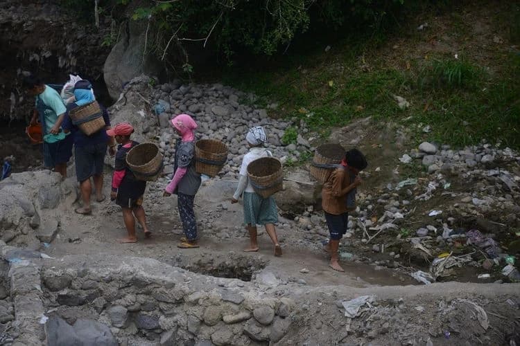 Potret buruh tambang sisa erupsi Gunung Merapi di Sungai Grawah, Desa Gubug, Cepogo, Boyolali, Jawa Tengah, Senin (13/7/2020). Mereka mendapat upah Rp 20.000 per hari jika material sisa erupsi Gunung Merapi yang mereka kumpulkan tersebut laku terjual.(KOMPAS/FERGANATA INDRA RIATMOKO)